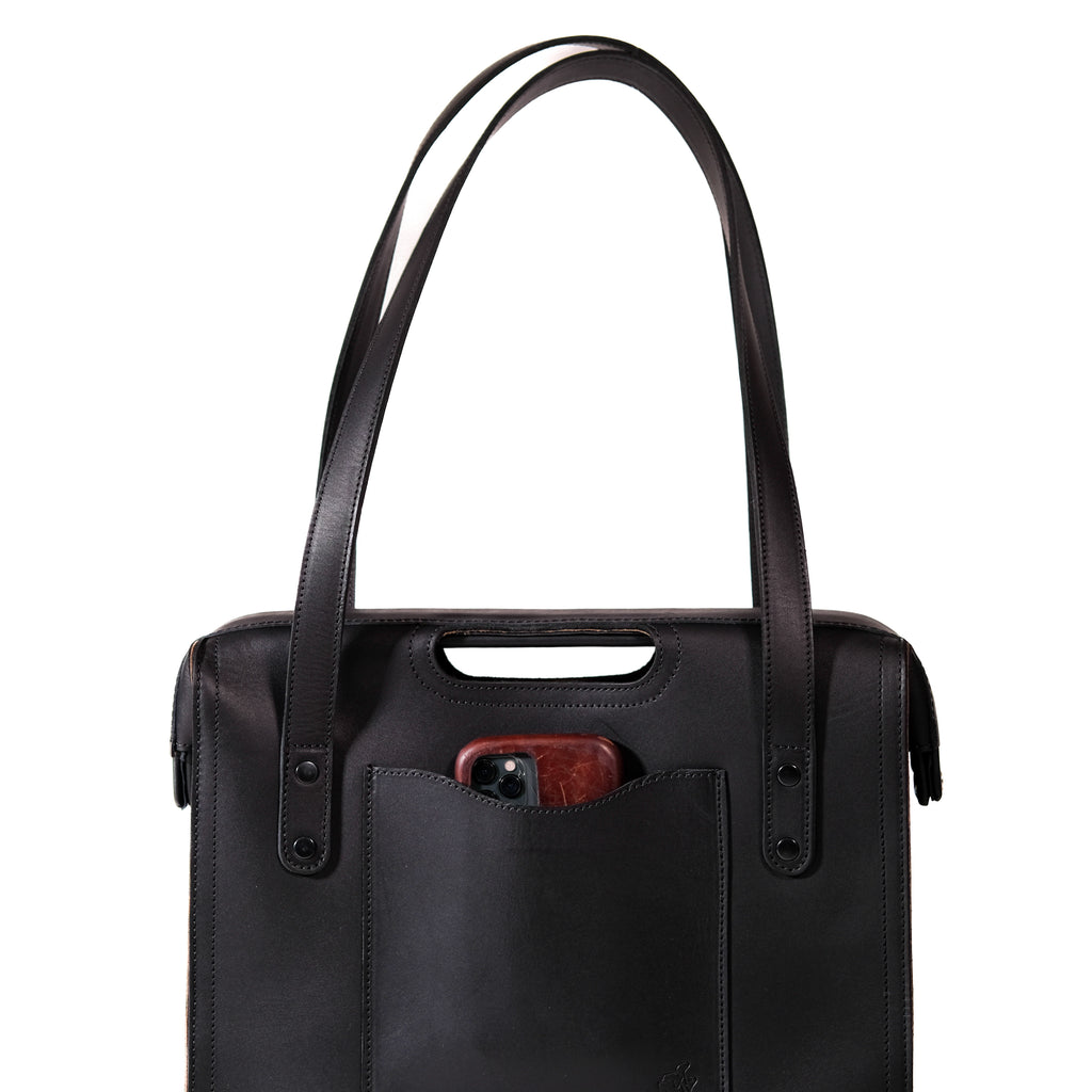 Professional Leather Tote in Black, close-up front view of shoulder handles and a phone in the front pocket