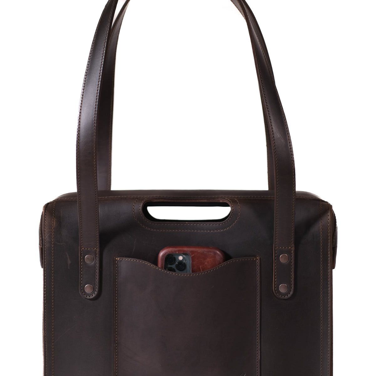 Professional Leather Tote in Dark Coffee Brown, close-up of the cutout grip, handles and a phone in the front pocket
