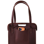 Professional Leather Tote in Chestnut, close-up front view of shoulder handles and a phone in the front pocket
