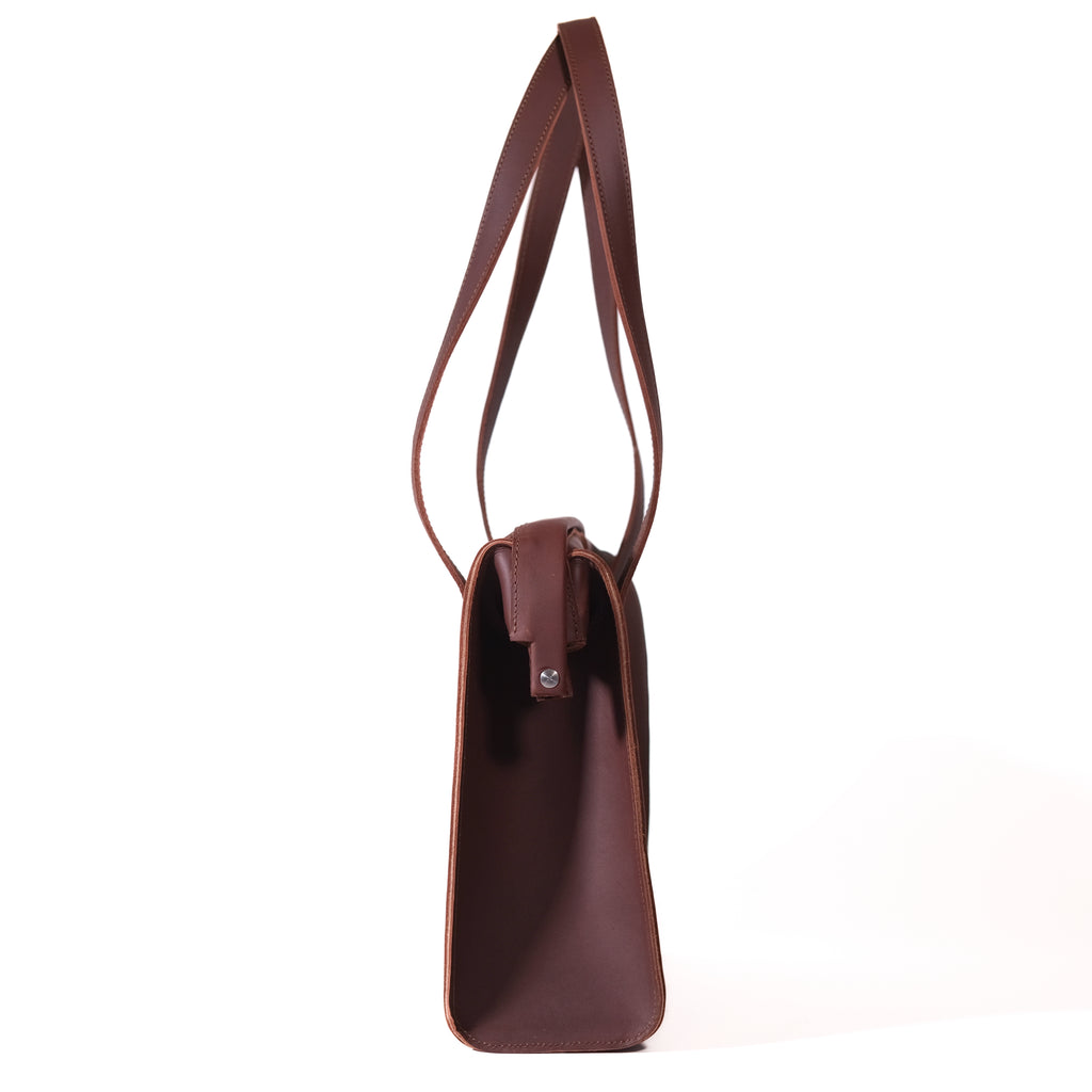 Professional Leather Tote in Chestnut, side profile view showing the slim gusset and shoulder handles