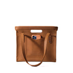 Professional Leather Tote in Tobacco, front view with handles lowered, cutout grip and a phone in the front pocket