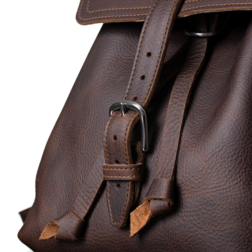 12" Drawstring Backpack in Dark Coffee Brown, close-up of front flap strap, buckle and drawstring ends