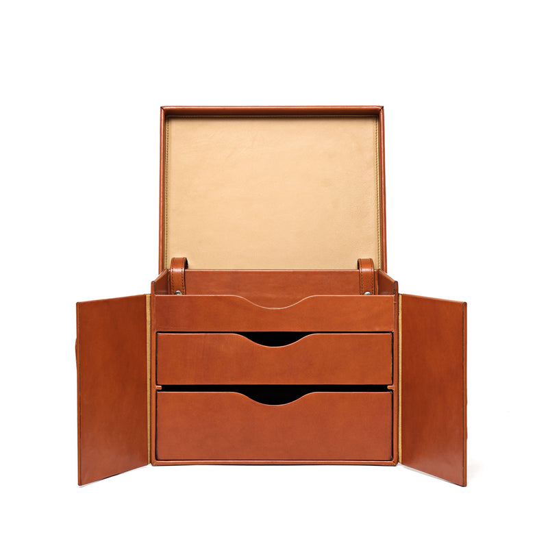 Tan leather case standing open, with two pull-out drawers, hinged side panels and a cream suede-lined lid.