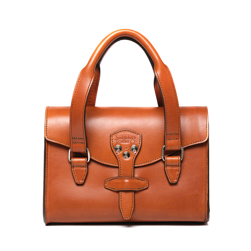 Tan leather handbag with two rolled top handles, a front flap and buckled straps at each side.