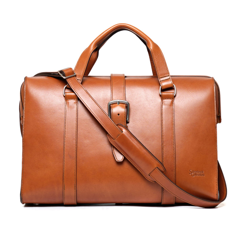 Tan leather duffle bag with a smooth front, a centre buckle strap and a shoulder strap.