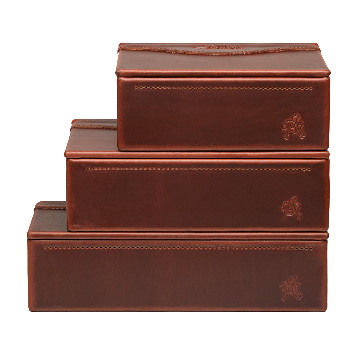 Small Organizer Box in Chestnut stacked on two larger Chestnut leather boxes, each with embossed logo