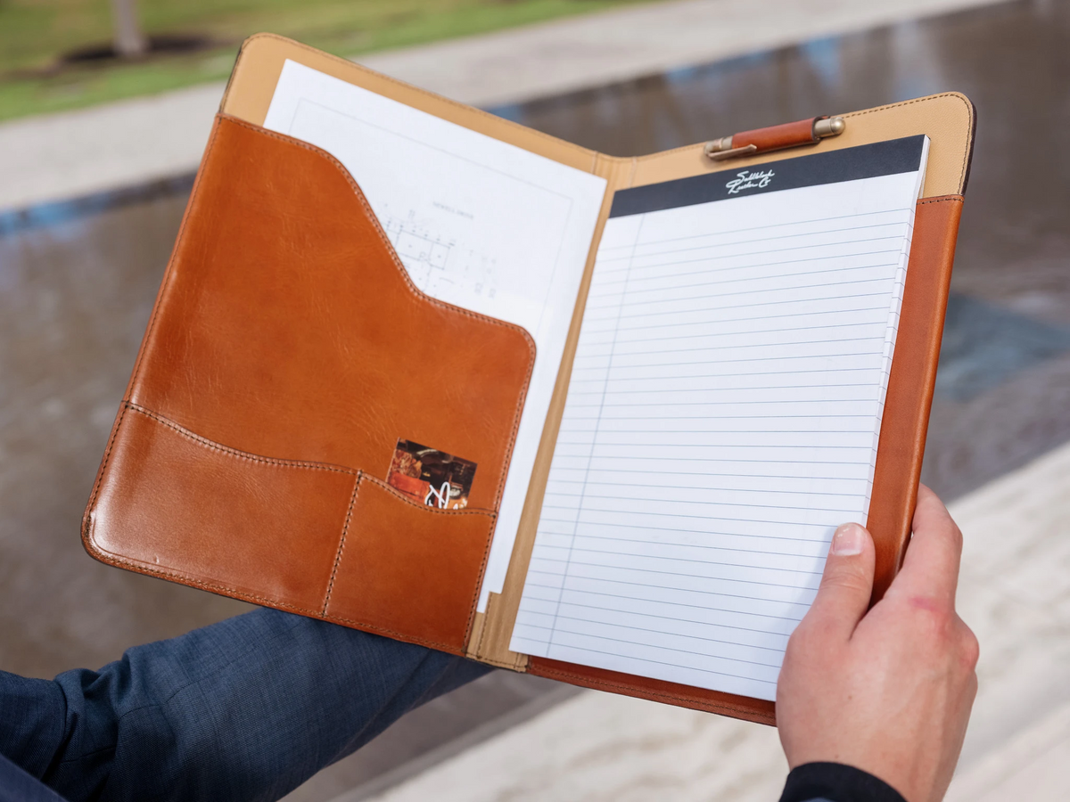 C.S. Lewis Medium Portfolio in English Tan held open in two hands, showing pockets, a business card and a legal pad