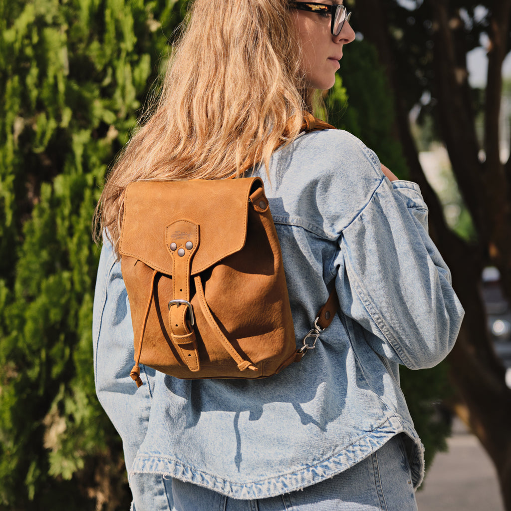 10" Convertible Crossbody in Tobacco, worn as a backpack by a woman in a denim jacket outdoors