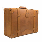 Grandfather Medium Suitcase in Tobacco, angled back view with top handle, straps and riveted corners