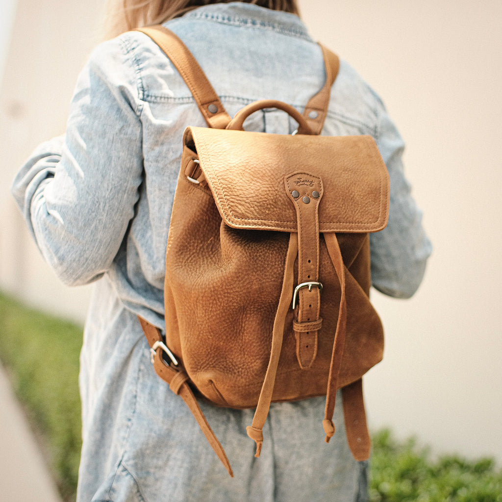 12" Drawstring Backpack in Tobacco, worn over a denim jacket, back view