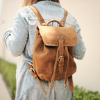 12" Drawstring Backpack in Tobacco, worn over a denim jacket, back view