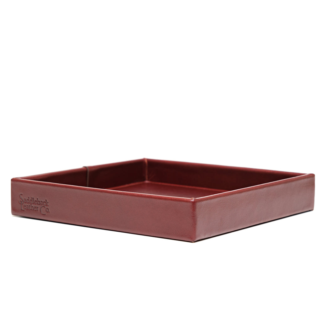 The Simple Leather Valet Tray in Oxblood, empty, low side view with embossed logo on the front edge