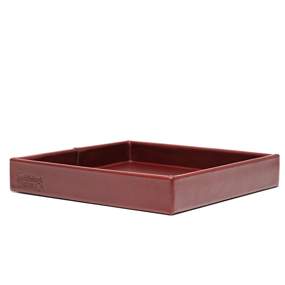 The Simple Leather Valet Tray in Oxblood, empty, low side view with embossed logo on the front edge
