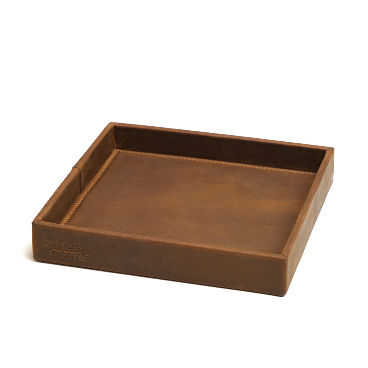 The Simple Leather Valet Tray in Tobacco, empty, angled view showing stitched corner seams and embossed logo